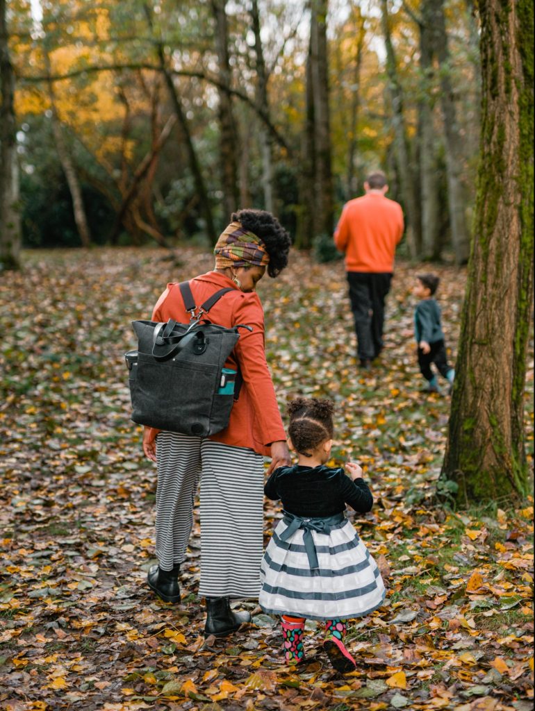 Family of four walking through the woods facing away from the camera