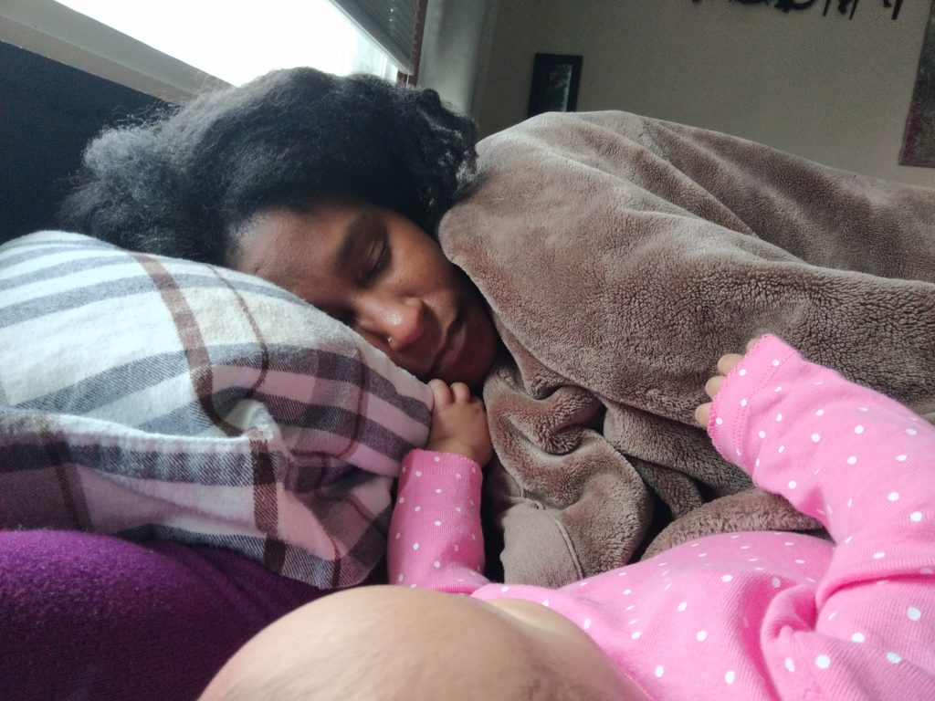 Woman sleeping next to baby